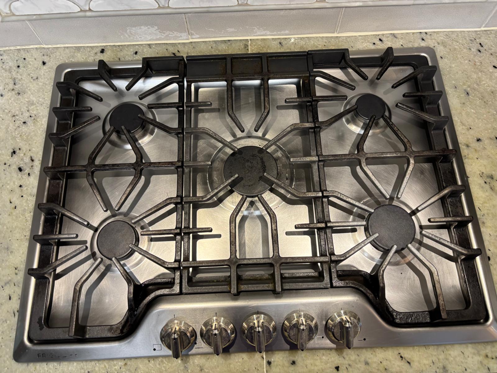 The same stainless steel gas cooktop after cleaning